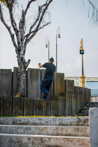 도시에 있는 콘크리트 벽을 기어오르는 사람 — 스톡 사진