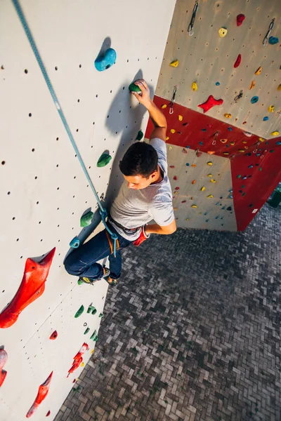 Homem parede de escalada com apertos — Fotografia de Stock