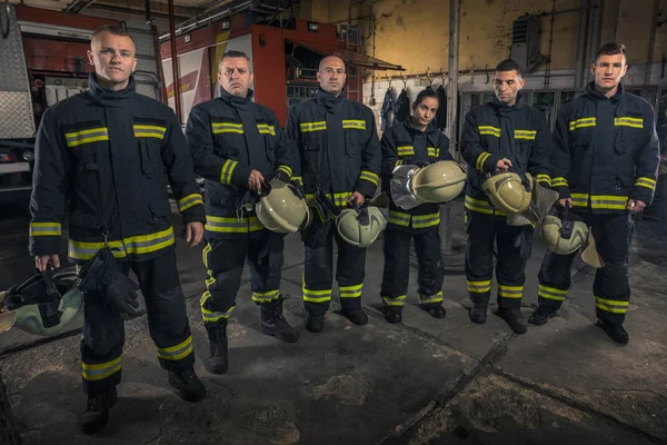 Portrait of firefighters standing by a fire engine. — Stock Photo, Image