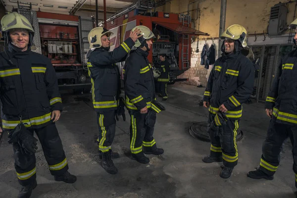 Firemen preparing for emergency service. Firefighters putting on — Stock Photo, Image