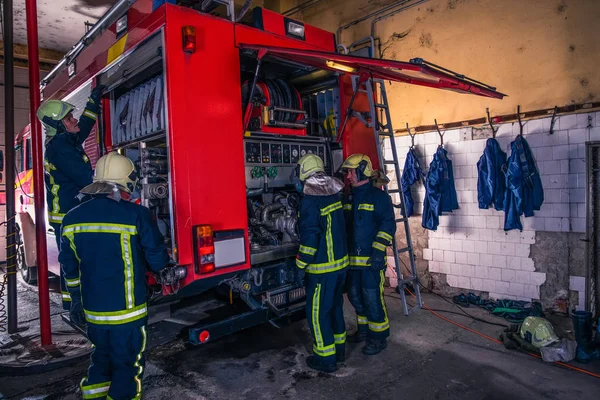 Grupo de bombeiros que preparam e inspecionam a pressão e detestam — Fotografia de Stock