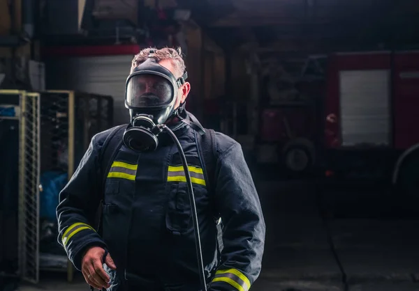 Bombero con uniforme protector usando máscara de oxígeno —  Fotos de Stock