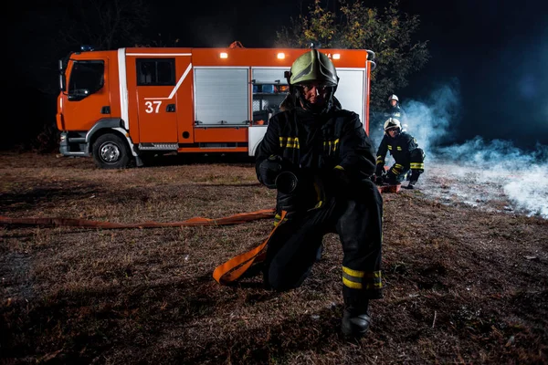 Brigada de incêndio em ação durante a noite — Fotografia de Stock