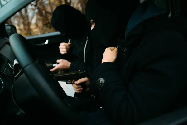 Bank robbers with their masks on pointing at the map prepared fo — Stock Photo, Image