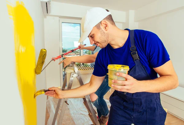 Cheerful married couple renovate living room while painting it w. —  Fotos de Stock