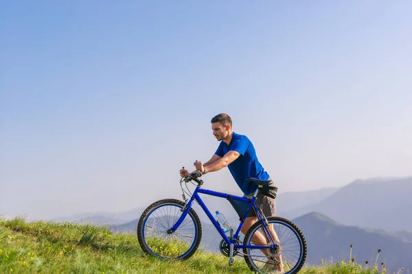 Fáradt fitt mountain bike-os nyomja a kerékpár felfelé a tetején t — Stock Fotó