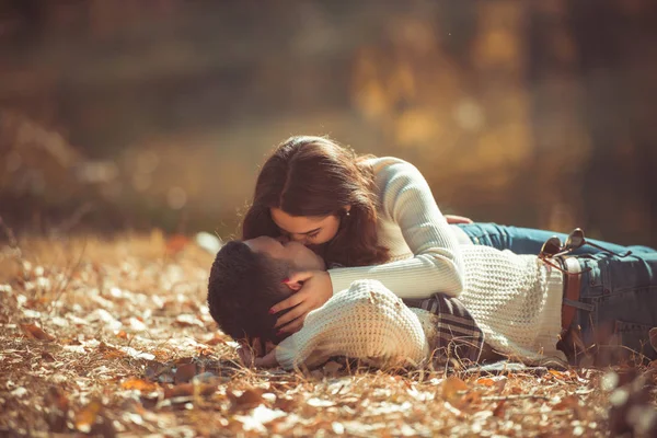 素敵なカップルが公園で秋の一日横になっている 彼らは幸せなキスをしながら探しています — ストック写真