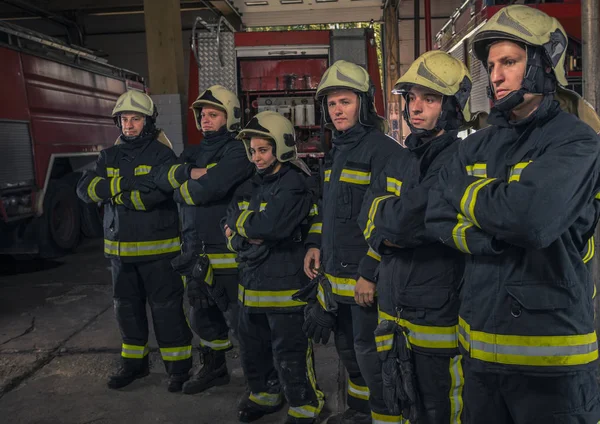 武装して自信を持って立って消防士のグループが交差した。火 — ストック写真
