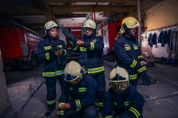 Portrait of group firefighters in front of firetruck inside the — Stock Photo, Image