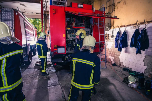 Gruppo di vigili del fuoco che preparano e ispezionano la pressione e mangiano — Foto Stock