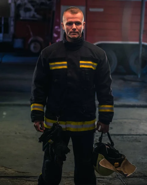 Portret młodego strażaka stojącego wewnątrz statystyki pożarowej — Zdjęcie stockowe