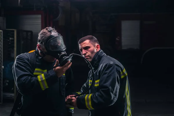Bomberos con uniforme protector usando máscara de oxígeno —  Fotos de Stock