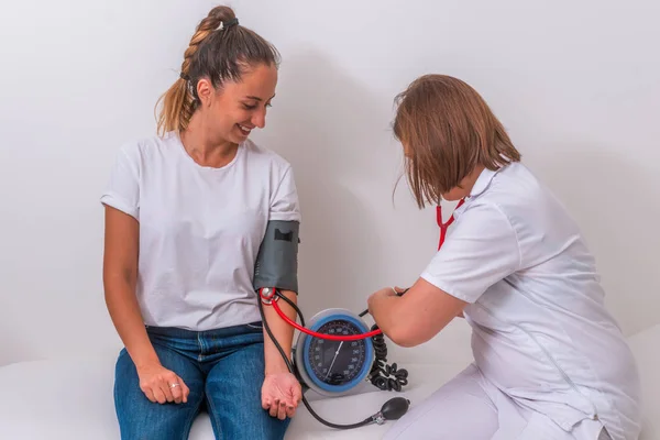 Médica do sexo feminino medindo a pressão arterial de sua jovem adolescente pat — Fotografia de Stock