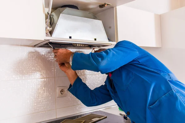 Reparador Maduro Iin Uniforme Azul Está Fijando Ventilación Cocina —  Fotos de Stock
