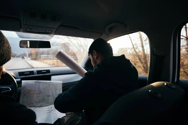 Dos ladrones violentos sentados en un coche mirando un plano de t — Foto de Stock