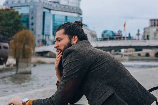 Snygg Hipster Med Långt Skägg Sittande Bänk Nära Flod — Stockfoto