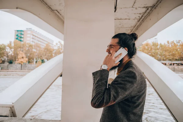 川遊歩道で長い髪とひげを持つ現代の若いビジネスマン — ストック写真
