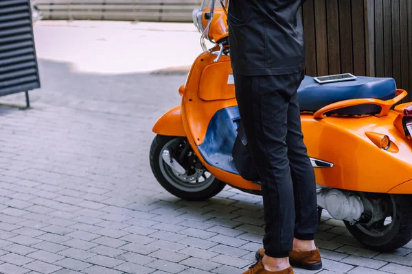 Turuncu Vespa Motosikletinin Yanında Sıradan Bir Adamı Duruyor — Stok fotoğraf