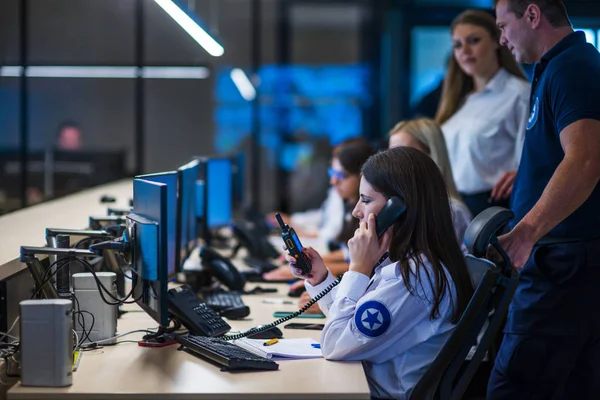 Security guards working in surveillance room. Female security gu