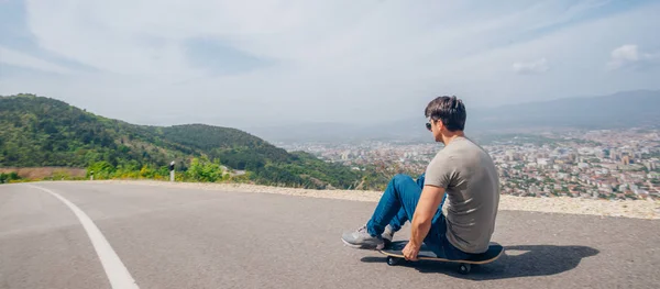 Urban cool longboarder preparing for a downhill ride(slide) doing few stunts and trick on his longboard, grabbing the board while riding.