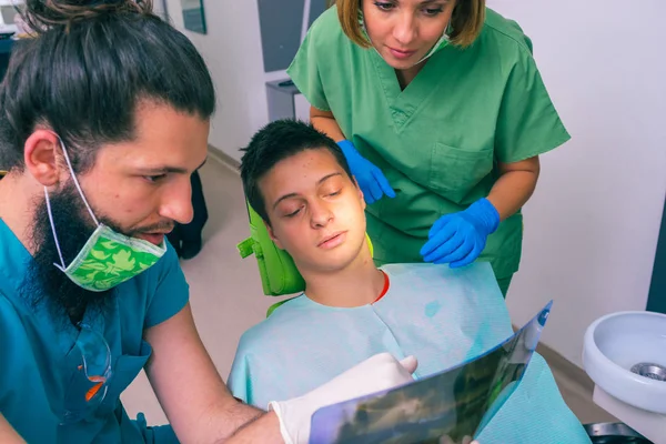 Dentistas Masculinos Femininos Mostrando Jovem Paciente Com Seus Dentes Imagem — Fotografia de Stock