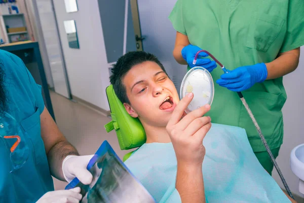 Mężczyzna Dentysta Pomocą Kobiety Dentysta Bada Usta Zęby Nastoletniego Chłopca — Zdjęcie stockowe
