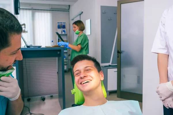Paciente Adolescente Feliz Está Sorrindo Para Seus Dentistas Enquanto Eles — Fotografia de Stock