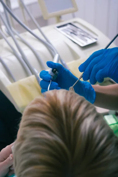 ゴム手袋を着用した女性歯科医は きれいな歯科ツールを使用して患者の歯をチェックします — ストック写真