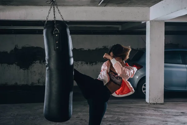 Giovane Sportiva Che Alto Calcio Durante Esercizio Boxe Garage — Foto Stock