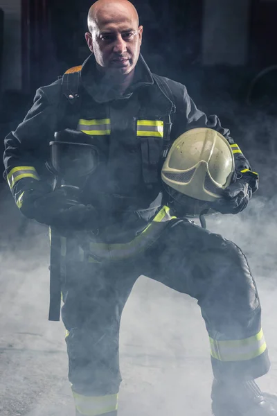 Fireman de pie confiando en mantener casco y usar bomberos —  Fotos de Stock