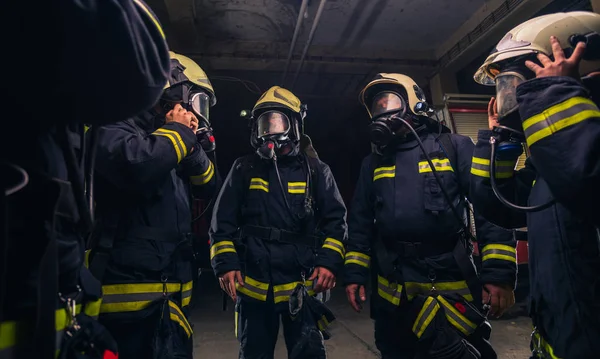 Squadra di vigili del fuoco nel reparto vigili del fuoco con maschere a gas e — Foto Stock