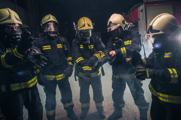 Equipe de bombeiros no departamento de bombeiros usando máscaras de gás — Fotografia de Stock