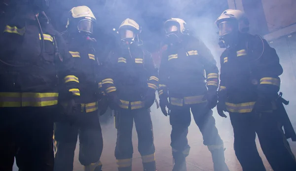 Portrait of group of firefighters in the middle of the smoke of — Stock Photo, Image