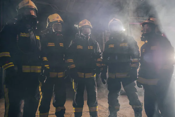 Porträtt av en grupp brandmän mitt i röken av — Stockfoto