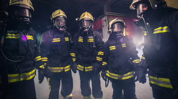 Equipe de bombeiros em pé no meio do extintor de incêndio — Fotografia de Stock