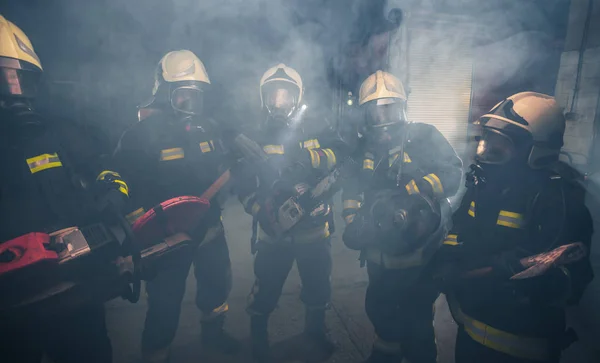 가스 마스크를 하고 있는 소방대원들 이 치실 한 가운데서 있다 — 스톡 사진