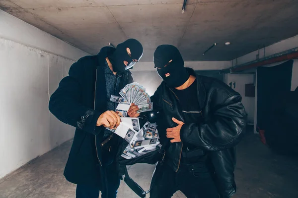 훔친 돈을 들고 있는 마스크를 쓴 도둑들 — 스톡 사진