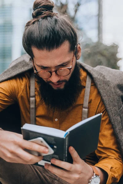 Bärtiger Mann Modischer Kleidung Mit Smartphone Und Buch — Stockfoto