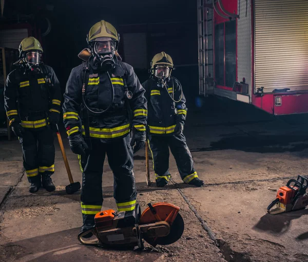 Skupina tří mladých hasičů pózujících uvnitř hasičů w — Stock fotografie