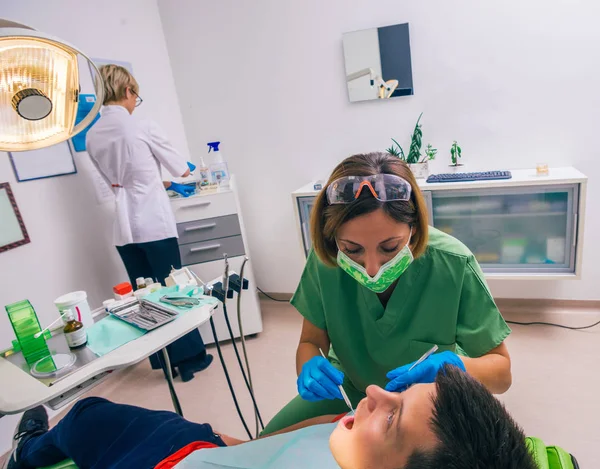 Jovem Garoto Paciente Está Sentado Cadeira Dentista Uma Dentista Feminina — Fotografia de Stock