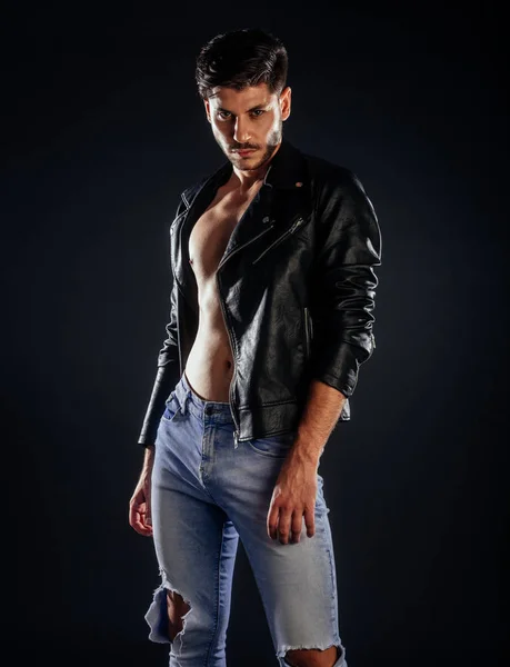 Portrait of an attractive guy posing in trendy leather jacket and jeans