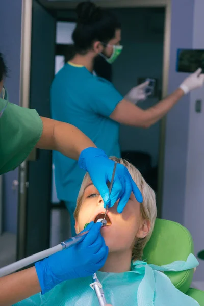 Una Dentista Femenina Trata Los Dientes Una Paciente Femenina Mientras — Foto de Stock