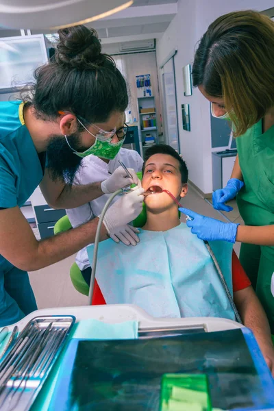 Equipe Dentistas Que Tratam Dentes Seu Jovem Paciente Usando Suas — Fotografia de Stock