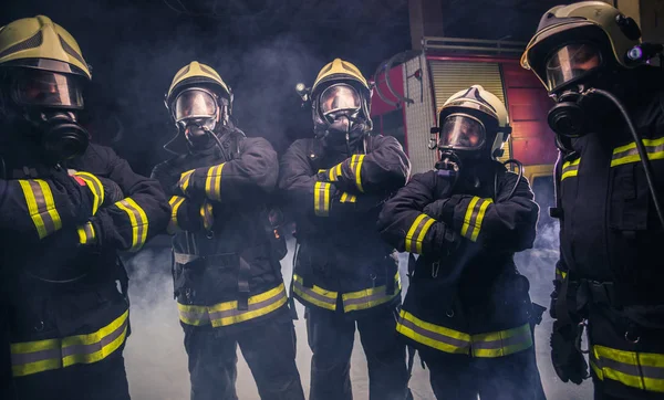 Equipo de bomberos en medio de los extintores de incendios. —  Fotos de Stock