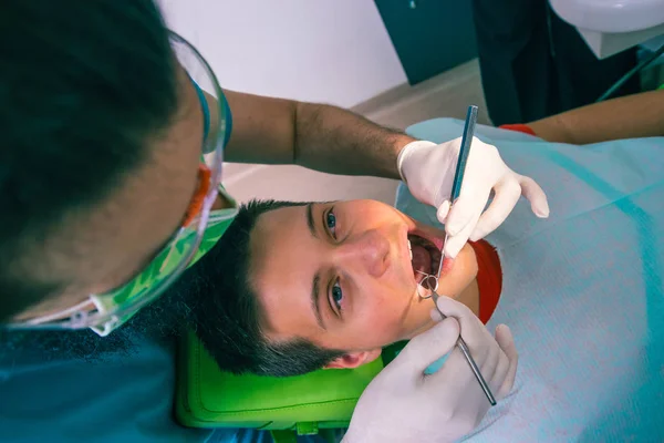 Zubař Vyšetřuje Zuby Teenagera Zubařském Křesle Zubařské Ordinaci — Stock fotografie