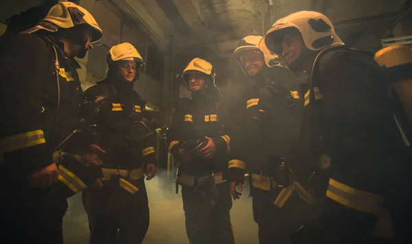 Gruppo di vigili del fuoco con uniforme all'interno della stazione antincendio prep — Foto Stock