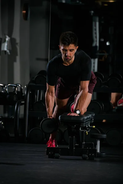 Spor salonunda zayıf kaslı adam ağırlık kaldırıyor. — Stok fotoğraf