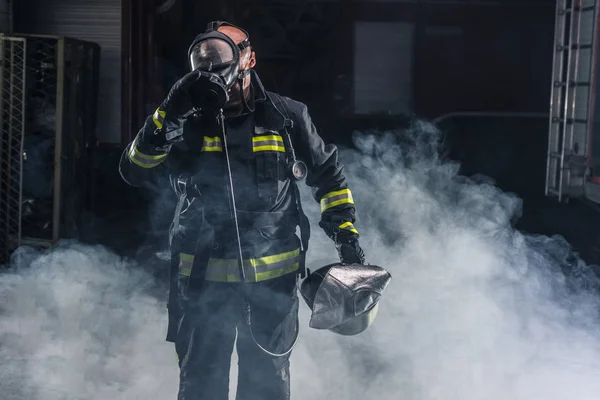 Fireman de pie confiando en mantener casco y usar bomberos —  Fotos de Stock