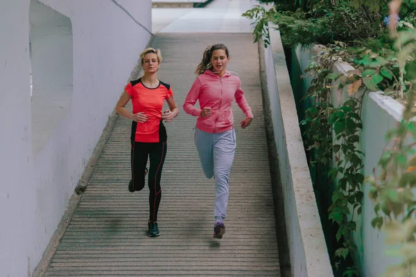两名迷人的女运动员在城市环境中慢跑 — 图库照片