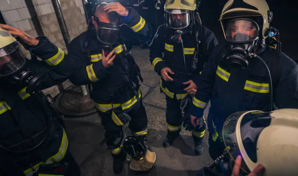 ヘルメットと防護服を着た消防団の中に立つ消防士のグループ — ストック写真